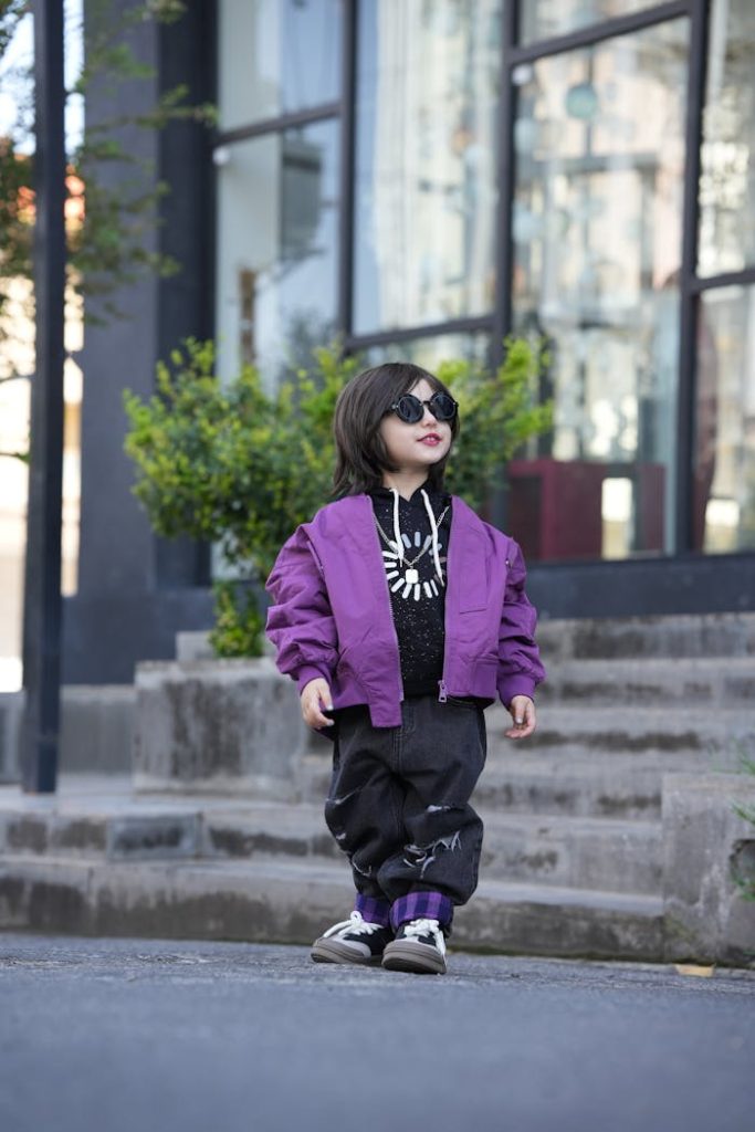 stylish-child-in-purple-jacket-and-sunglasses-outdoors-28808420 Stylish Child in Purple Jacket and Sunglasses Outdoors